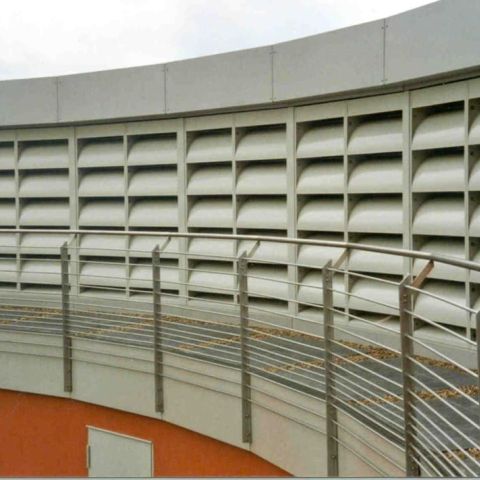 Beige-graue Schallschutz-Lamellenwand mit Gang und Geländer davor
